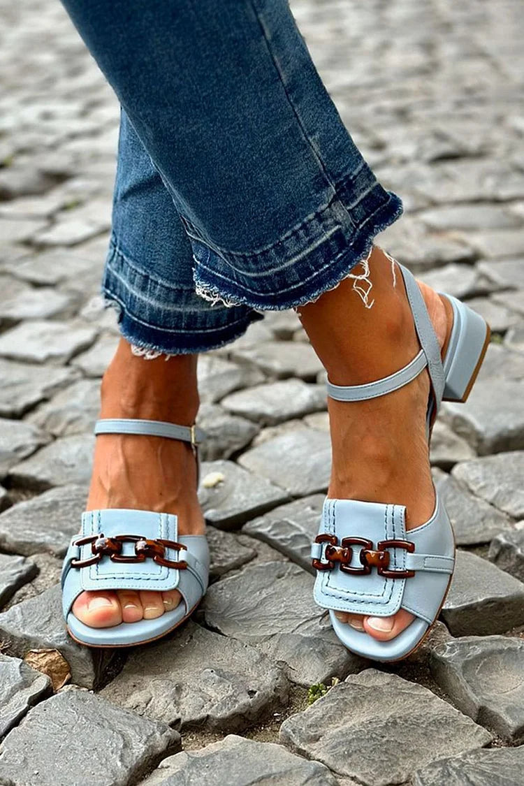 Tacones bajos azules con cadena metálica y costuras a la vista