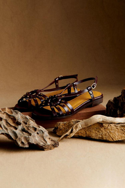 Sandalias con tachuelas metálicas y aberturas en marrón oscuro